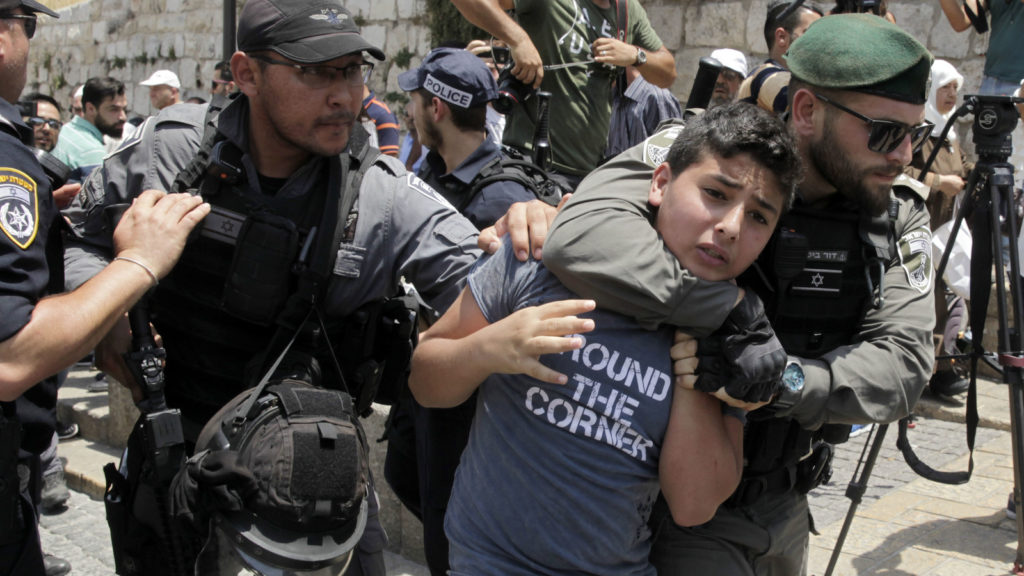 La polizia israeliana stringe il collo a un ragazzo palestinese che rischia di soffocare nella città vecchia di Gerusalemme, 17 luglio 2017. Mahmoud Illean | AP